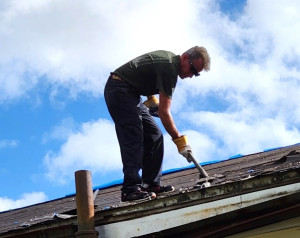 Jay Hosty on roof removing shingles