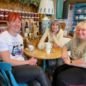 Three shop workers enjoy a coffee in a cafe