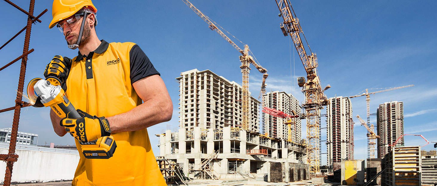 Construction site scene with tower cranes and high-rise buildings under construction in background against blue sky.