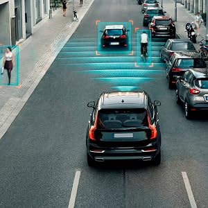 Sequential images showing car on road with blue visualization of blind spot detection system, demonstrating vehicle safety feature in action.