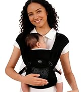 Woman wearing black and white baby carrier/sling holding infant against her chest. Structured soft carrier with padded shoulder straps and ergonomic design for hands-free infant transport.