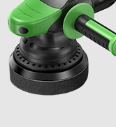 Partial view of a green and black power tool, likely a drill or driver. Digital display visible on the tool's body.