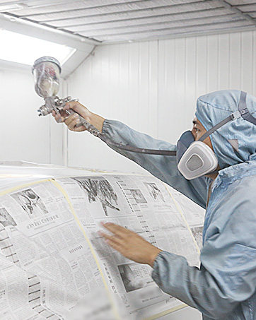 Spray gun accessory kit packaging displayed with contents including multiple nozzles, fluid containers, brushes, cleaning tools, measuring cup with measurement markings, and various small components.