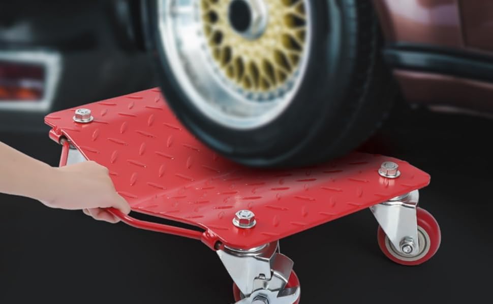 Red automotive dolly with diamond plate surface pattern and four swivel casters, shown in use under a car tire. Heavy-duty construction with visible mounting bolts.