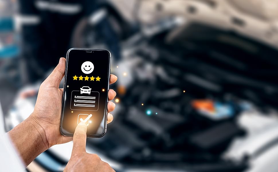 Smartphone displaying a smiley face icon and menu options, held in front of a car engine compartment, demonstrating a vehicle diagnostic or control app.