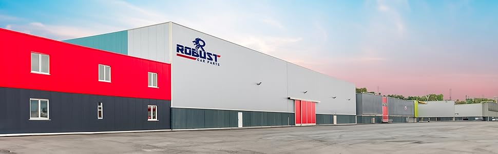 Large industrial building with red and gray exterior, featuring 'BORAS' signage. Multiple garage doors visible along the front facade.