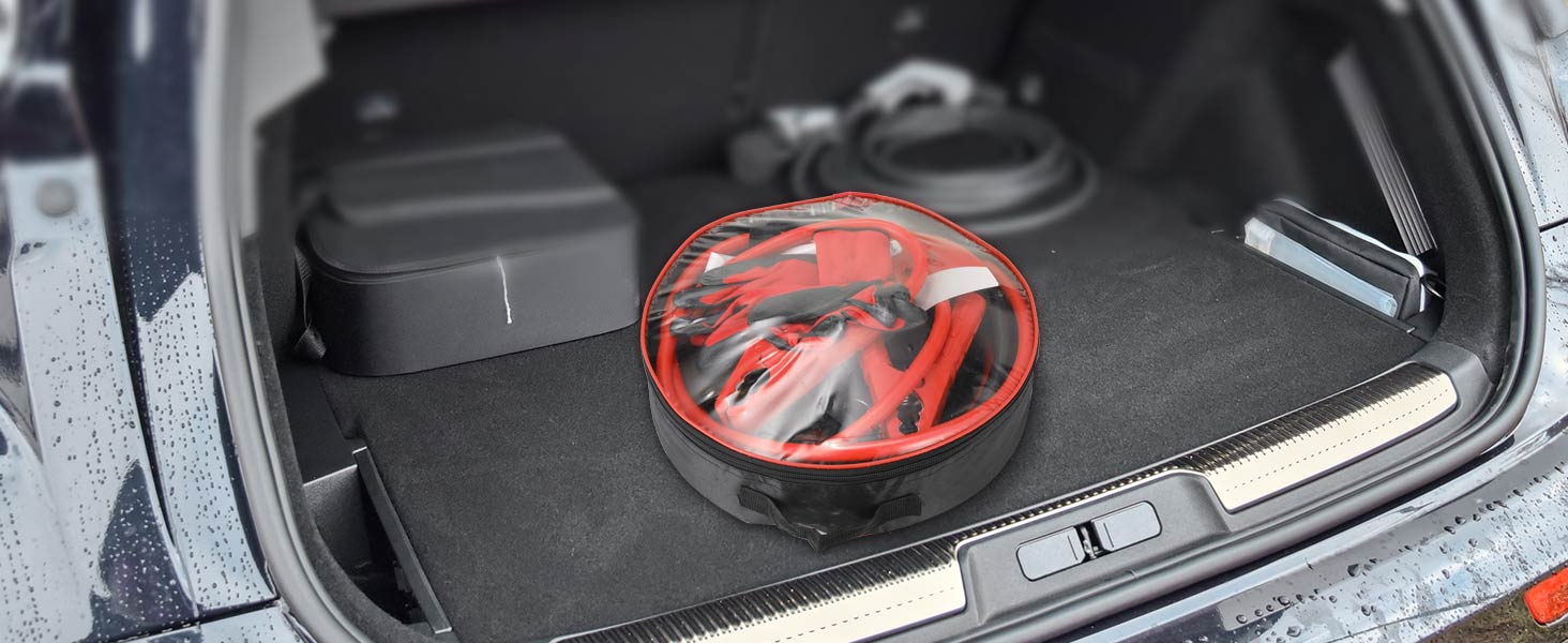 Car trunk interior with jumper cables in a red circular case, showcasing emergency equipment storage in a vehicle.