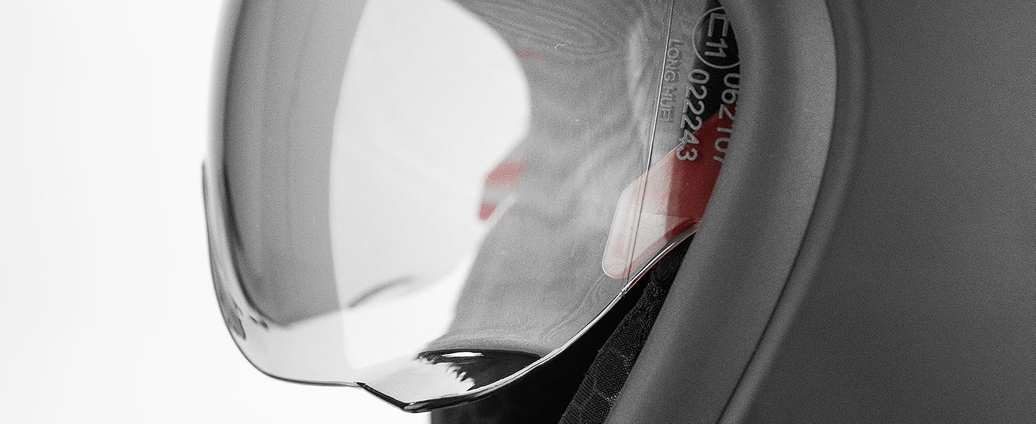 Close-up of protective headgear or helmet with clear visor, black outer shell, gray padded interior visible, and red accent detail on white underside.
